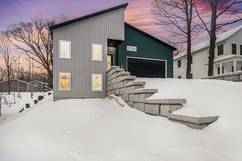 Contemporary house with unique roof design in winter setting.