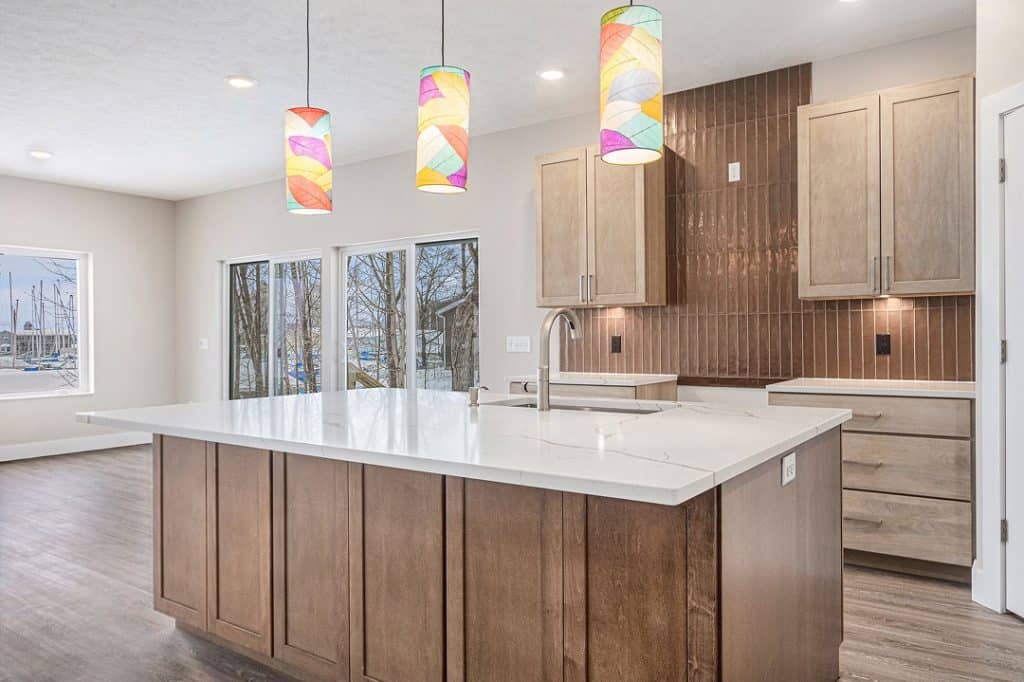 Contemporary kitchen with island, pendant lights, and wooden cabinets.