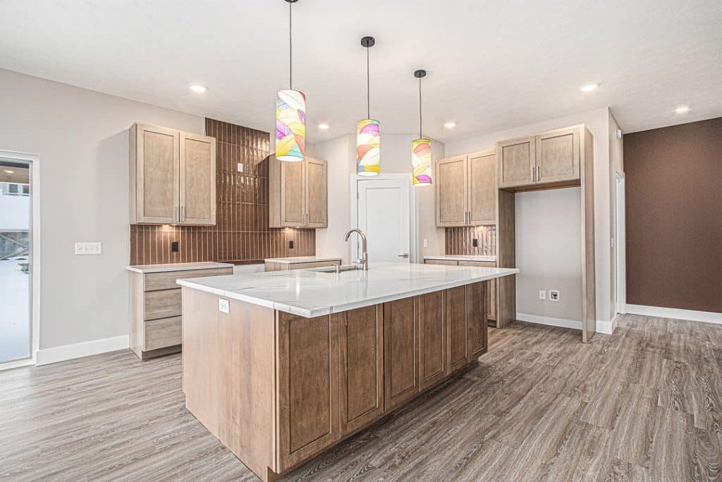 Contemporary kitchen with island, pendant lighting, and wooden cabinets.