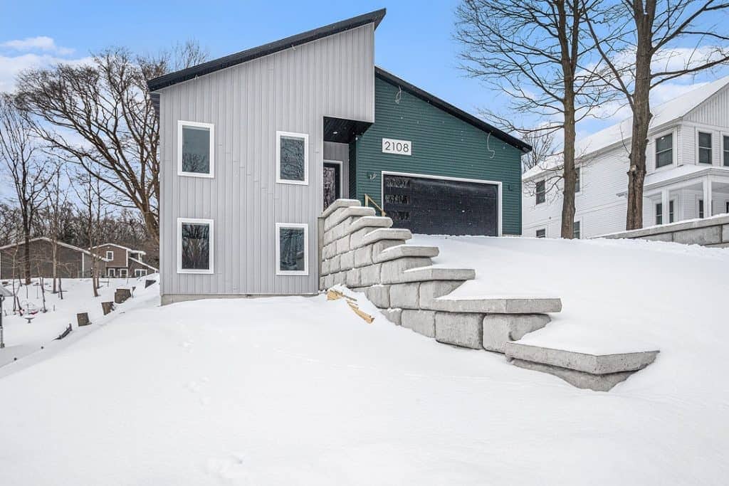 Contemporary custom home with unique architecture in snowy landscape.
