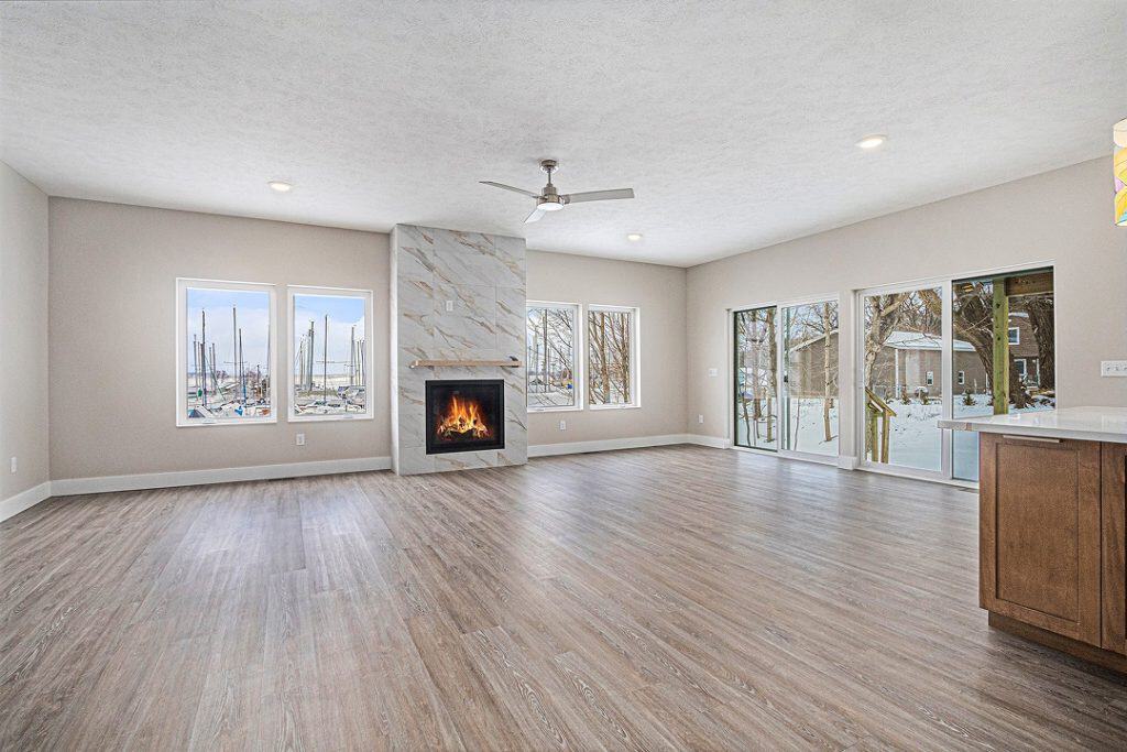 Bright living room with fireplace, large windows, and sliding glass doors.