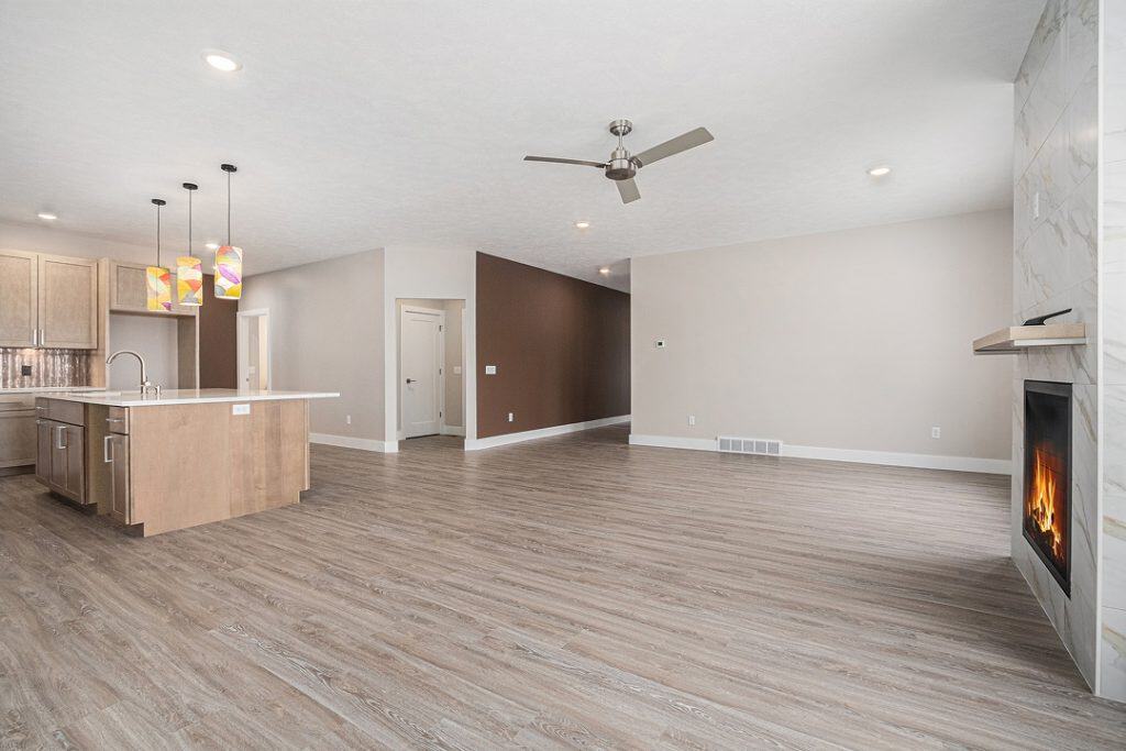 Spacious living room with modern design, hardwood floors, and a fireplace.