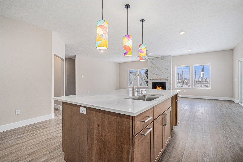 Contemporary kitchen with island, pendant lights, and large windows in a new home.