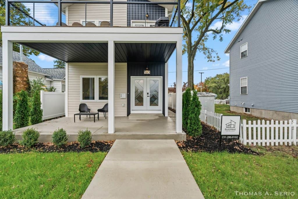 Contemporary house with front porch, outdoor seating, and landscaped yard.