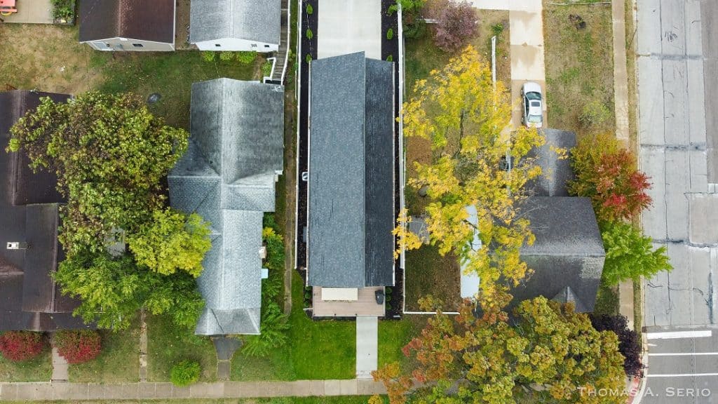 Aerial view of custom homes with trees and streets in a residential neighborhood.