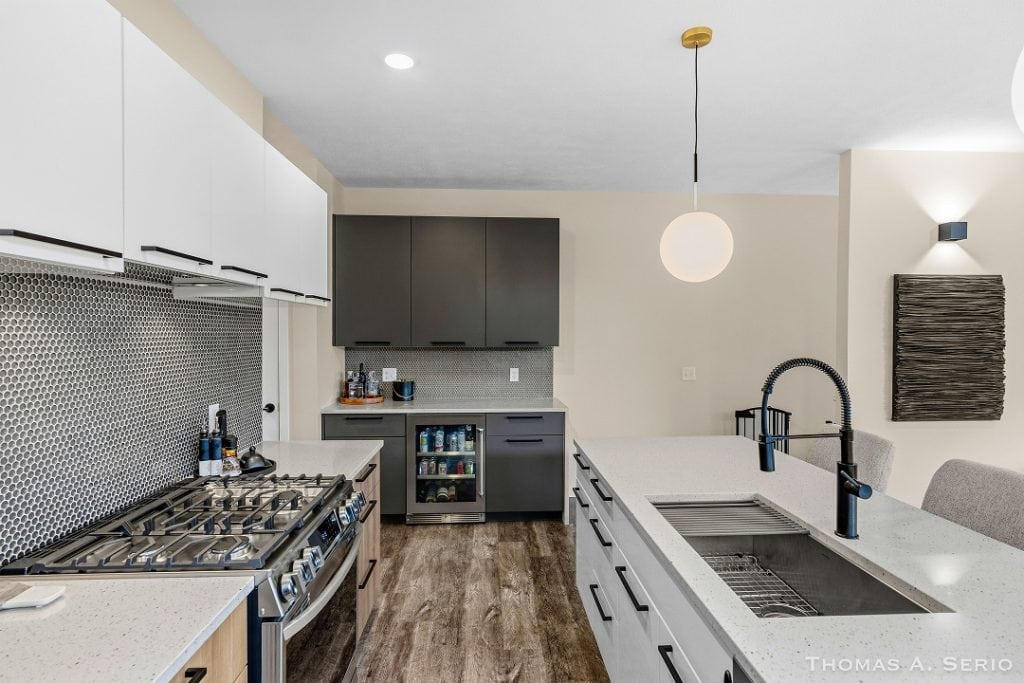 Contemporary kitchen with white cabinets, black accents, and stainless steel appliances.