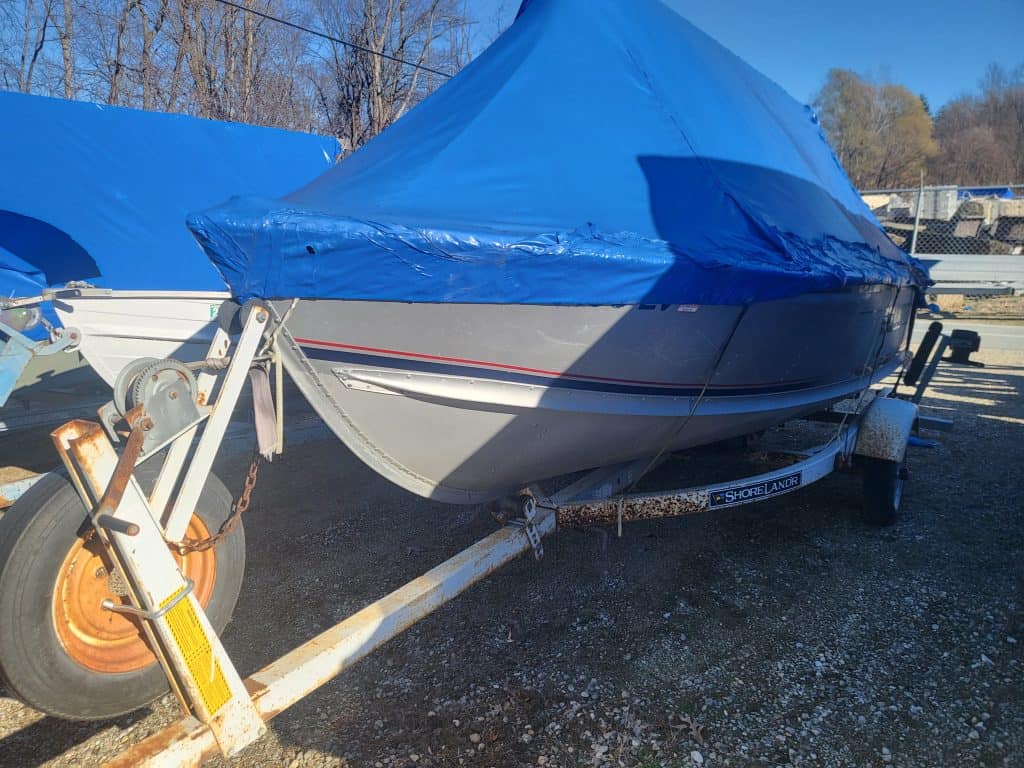 Alumacraft Lunker 14 boat covered with blue tarp on trailer for sale.