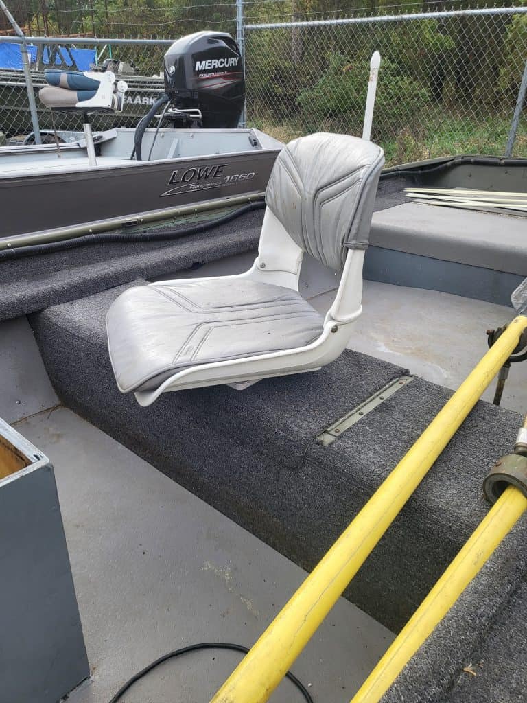 Boat seat on a fishing boat with Mercury outboard motor in background.