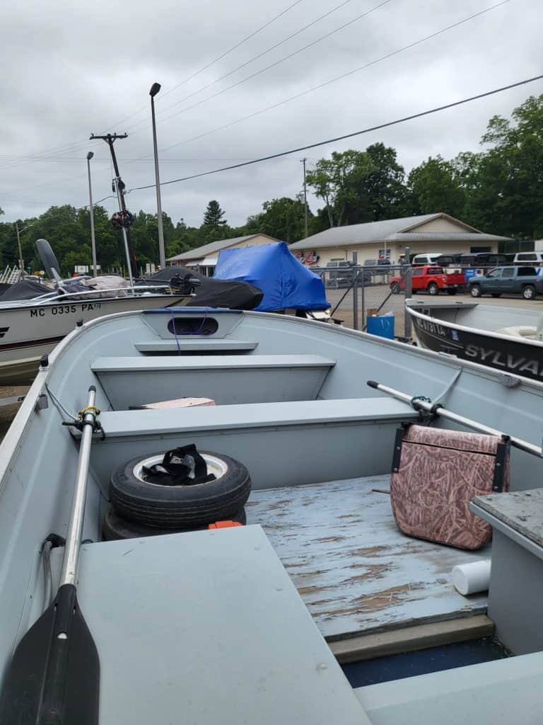 Used Sea Nymph 16 HD Camp boat with gear and accessories in a parking lot.