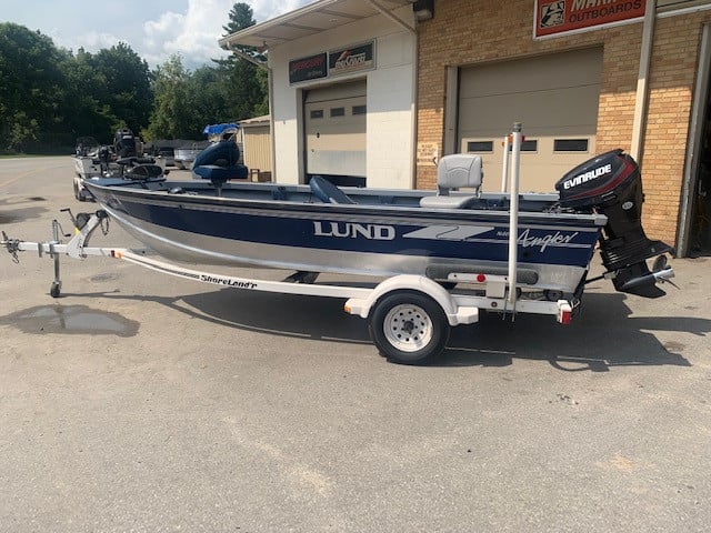 Used 1996 LUND 1650 Angler fishing boat on trailer at dealership.