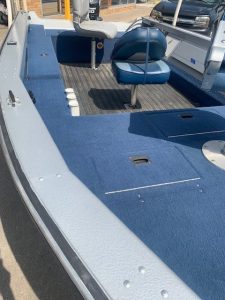 Interior view of a used 1996 LUND 1650 Angler boat with blue seats and carpet.