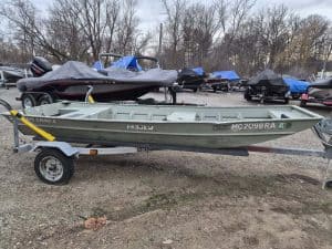 Used 1997 SmokerCraft 1436 boat on trailer at boat dealership.