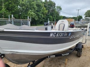 Used Sylvan 14 utility boat on trailer with outboard motor and seating.