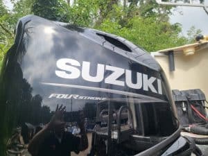 Black Suzuki outboard motor with four-stroke label for boats.