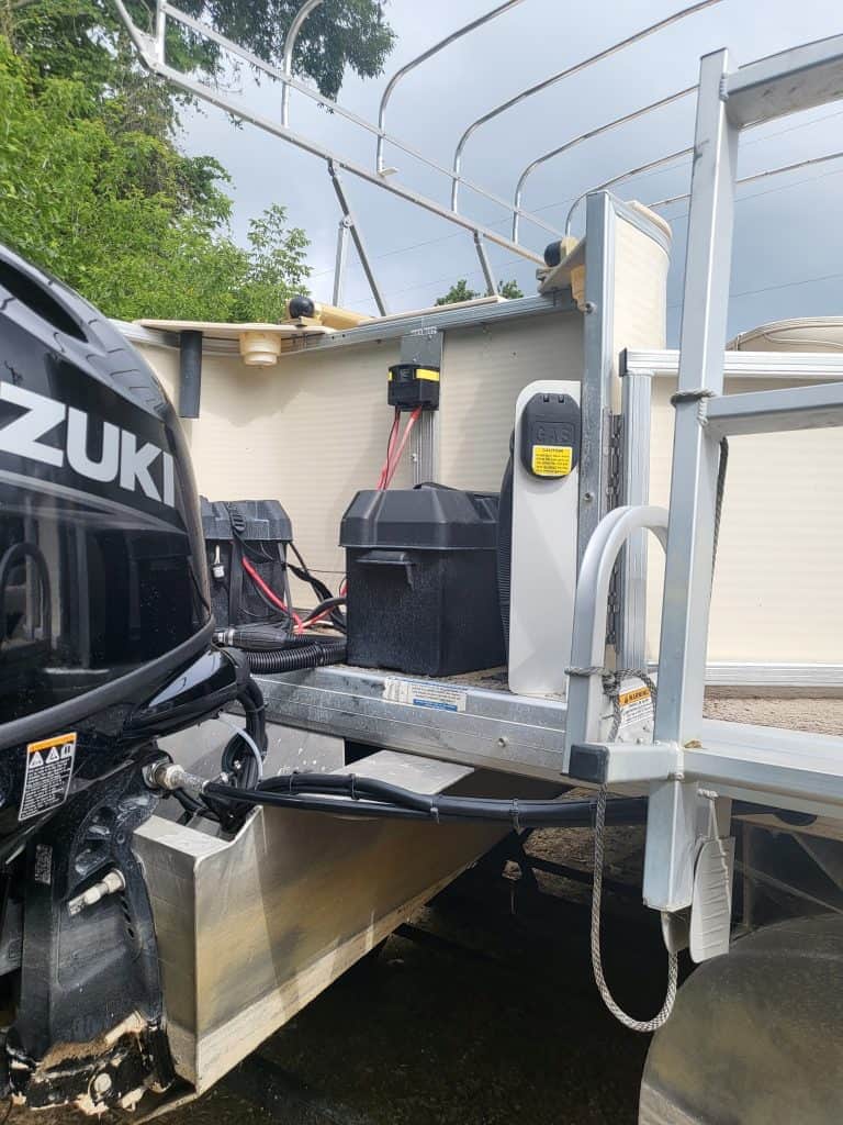 Close-up of boat's engine and battery setup on a 2010 Sweetwater 23 Fish pontoon boat.