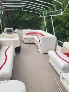 Interior view of a Sweetwater 23 Fish pontoon boat with white and red seating.