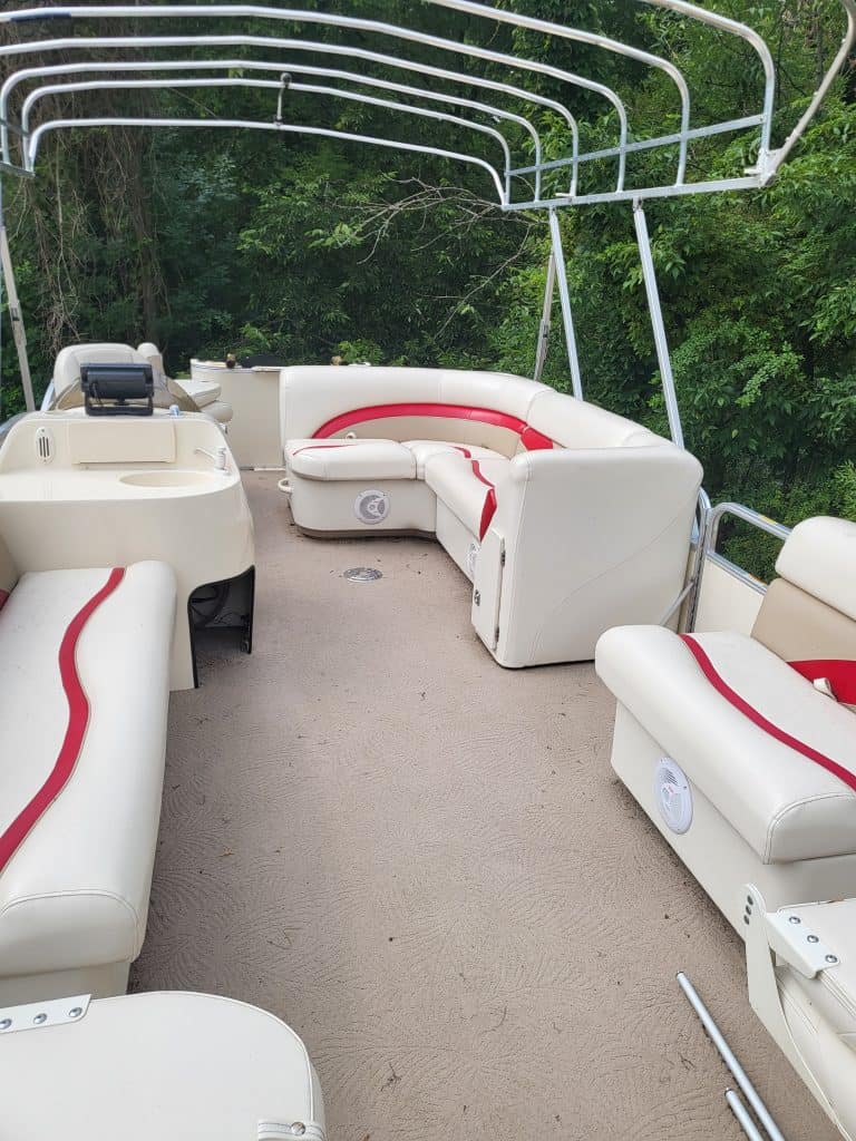 Interior view of a Sweetwater 23 Fish pontoon boat with white and red seating.