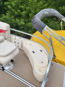 Pontoon boat with fishing and lounging features on water.