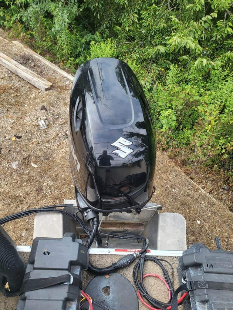 Outboard motor for boat with Suzuki logo, outdoor setting.