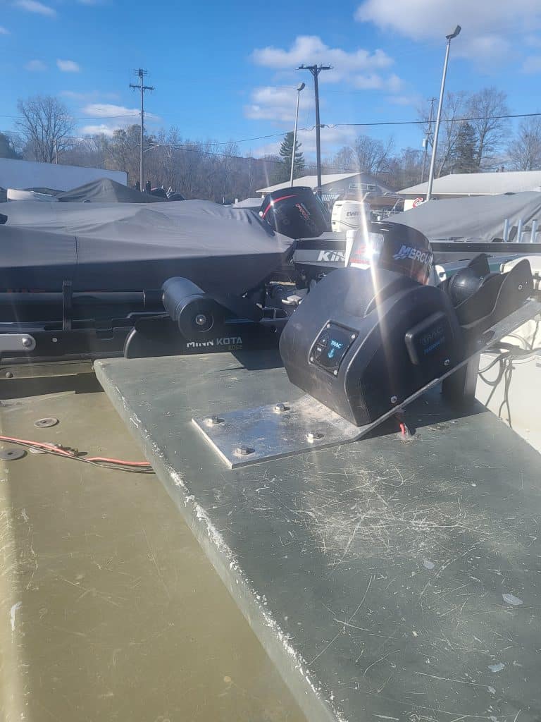 Lowe 15' 10 jon boat with outboard motor on trailer in outdoor setting.