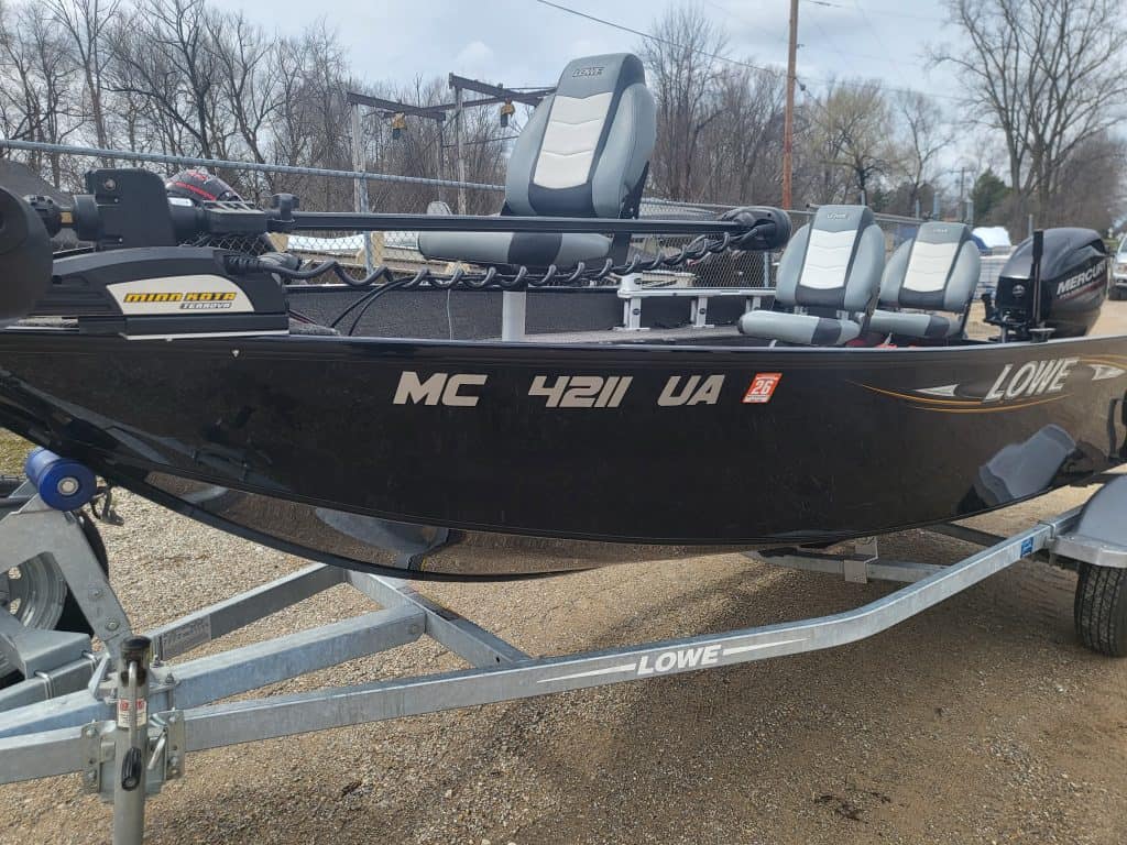 Used Lowe FM160 fishing boat on trailer with seats and trolling motor.