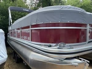 Lowe SS210 pontoon boat with red exterior and gray canopy on trailer.