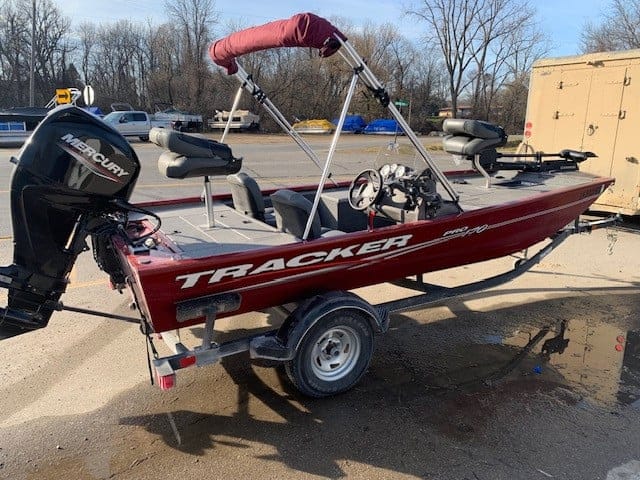 Red Bass Tracker 17 boat with Mercury outboard motor on trailer.