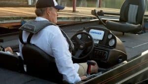 Boat captain operating a boat with marine electronics and safety gear.