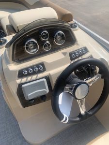 Boat dashboard with gauges and steering wheel for Lowe SS210 model.
