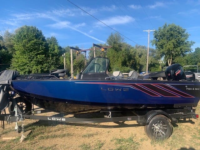 Lowe FS18 boat with Mercury outboard motor on trailer in outdoor setting.