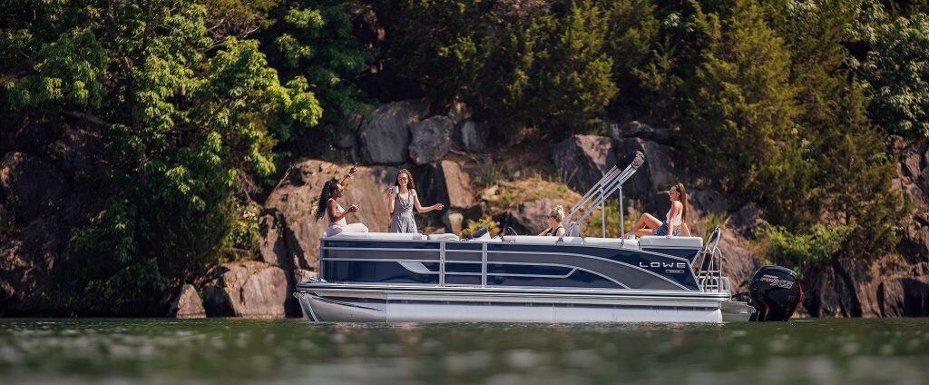 Lowe SS210 boat with passengers on a lake surrounded by trees.
