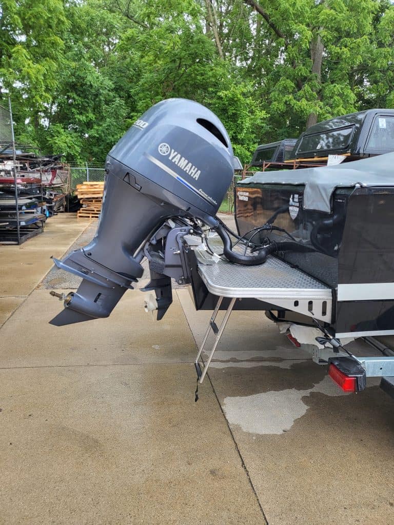 Yamaha outboard motor attached to boat on trailer in outdoor setting.
