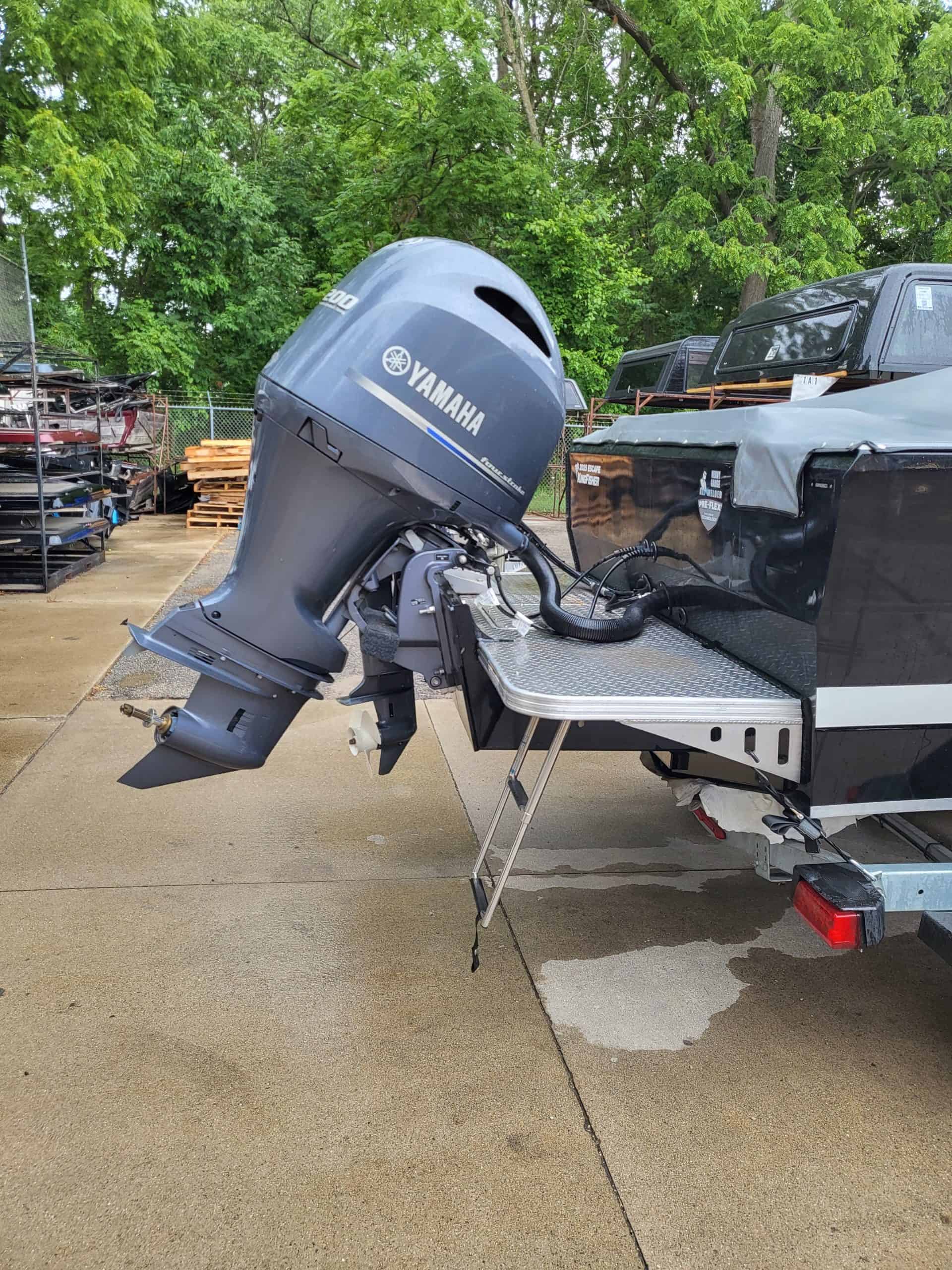Yamaha outboard motor attached to boat on trailer in outdoor setting.