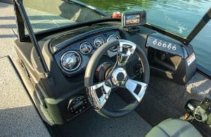 Boat dashboard with steering wheel, gauges, and GPS navigation system.