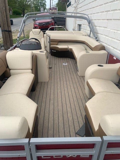 Interior view of Lowe Boats SS 210 pontoon boat with beige seating and wooden flooring.
