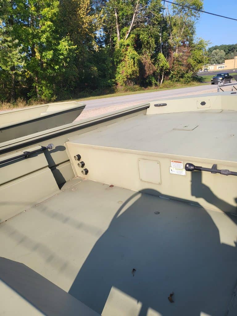 Close-up of boat deck at Camp & Cruise, showcasing outdoor storage and scenic natural background.