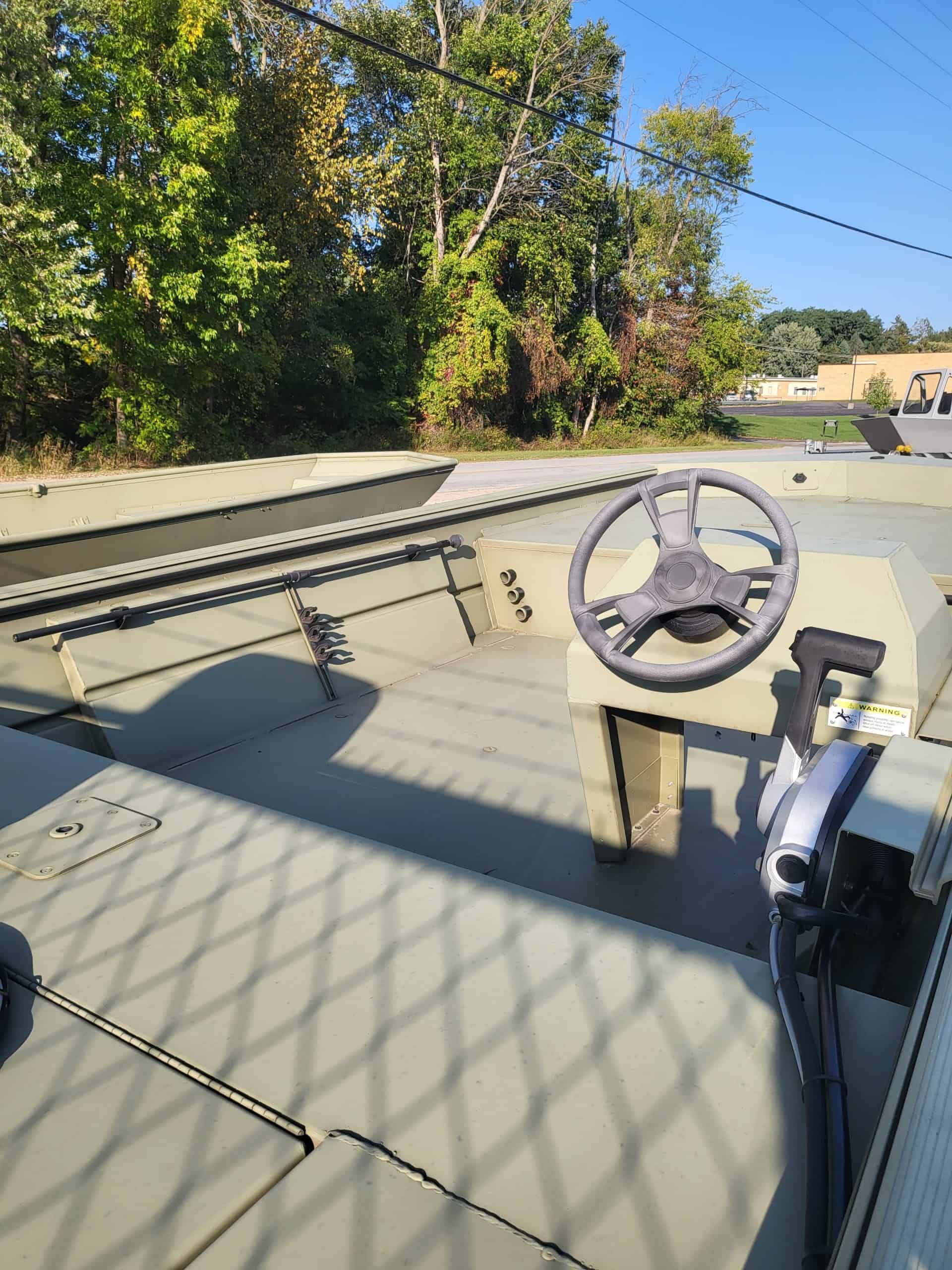 Close-up of boat interior and steering wheel at Camp & Cruise for boating enthusiasts.