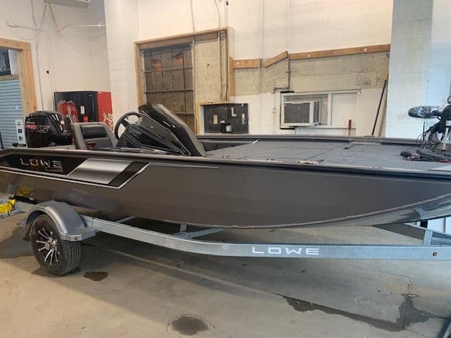 Lowe Stinger 188 fishing boat on trailer in indoor storage.