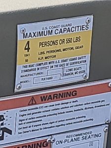 U.S. Coast Guard capacity plate showing 4 persons or 550 lbs limit.