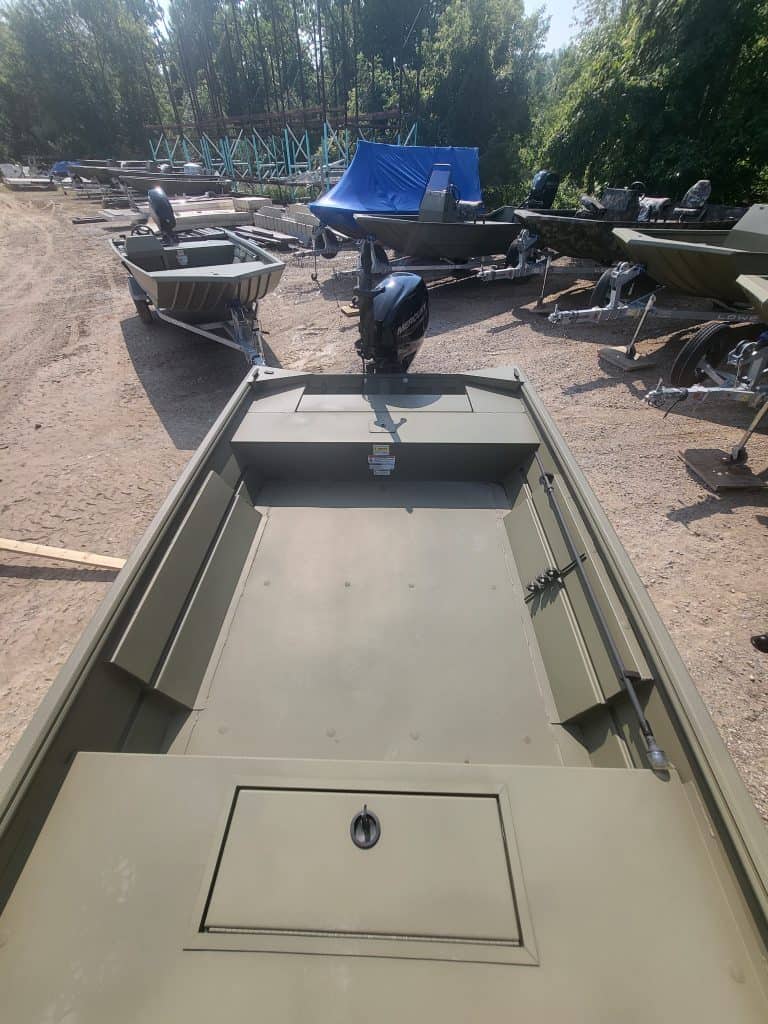 View of a boat storage lot with various boats and outboard motors.