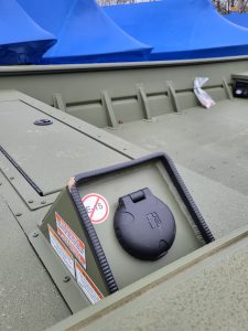 Close-up of boat interior with fuel cap and storage compartments.