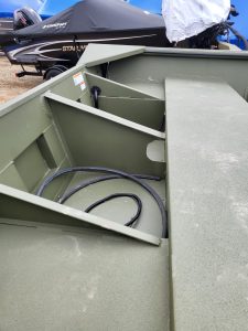 Close-up of boat interior with wiring and storage compartments.
