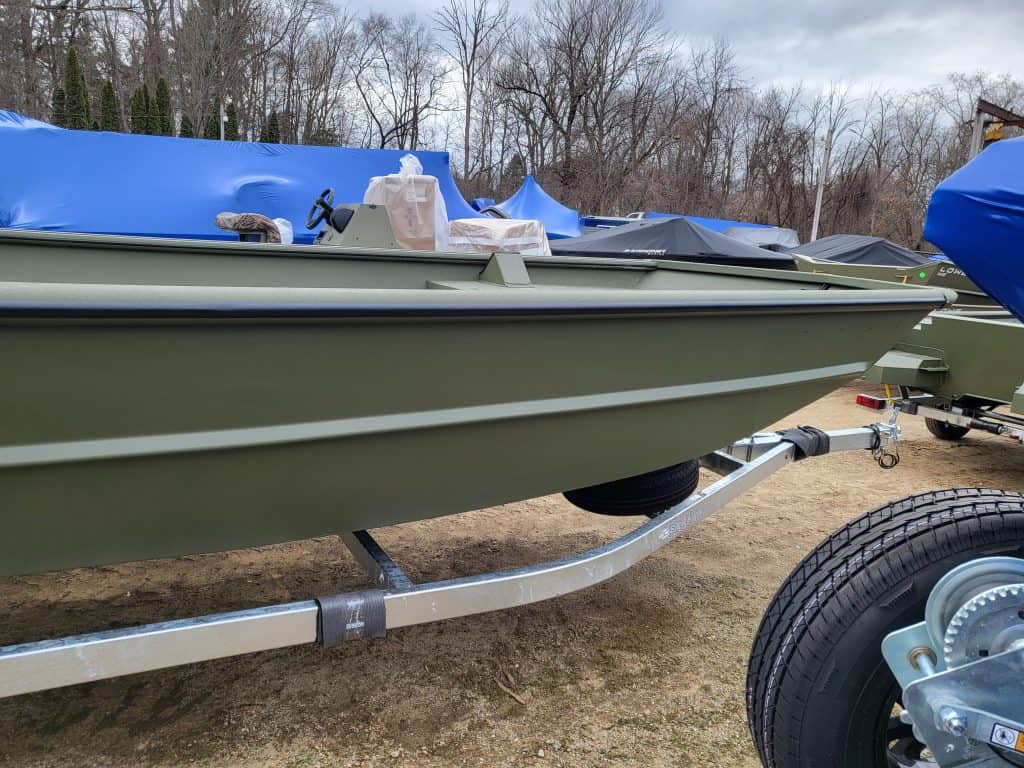 Green SeaArk 2072 MVT boat on trailer at boat dealership lot.