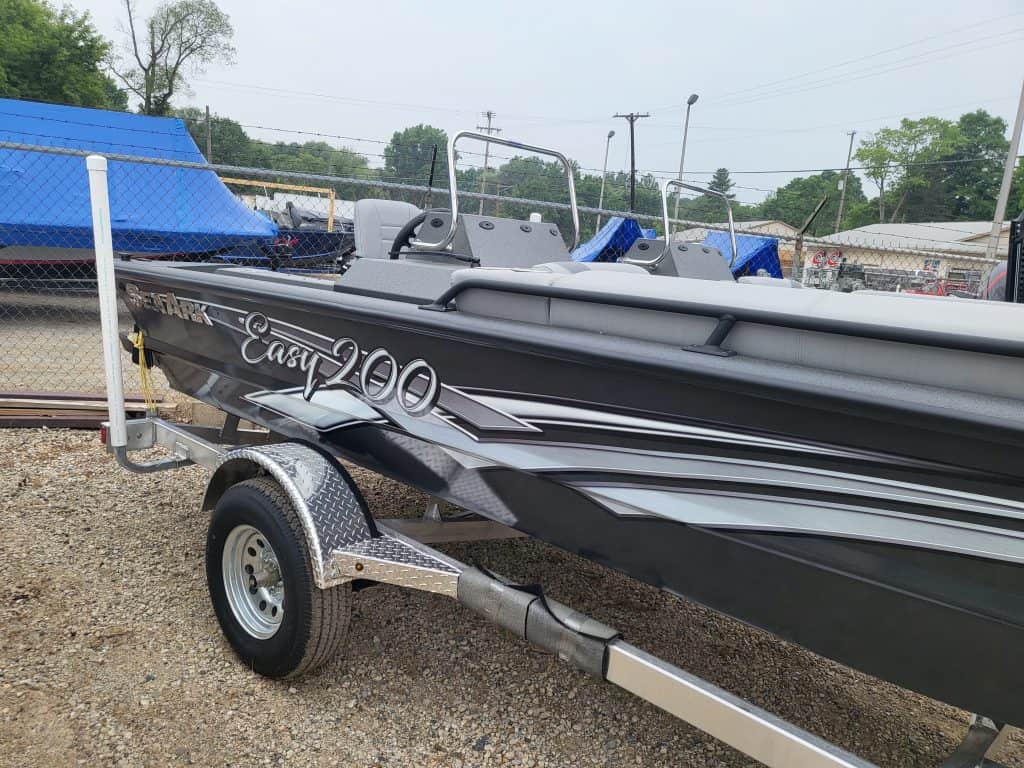 Black and gray SeaArk Easy 200 boat on trailer at dealership.