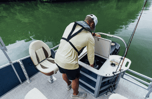 Man fishing from a Lowe Boats SF212W with fishing gear and water background.