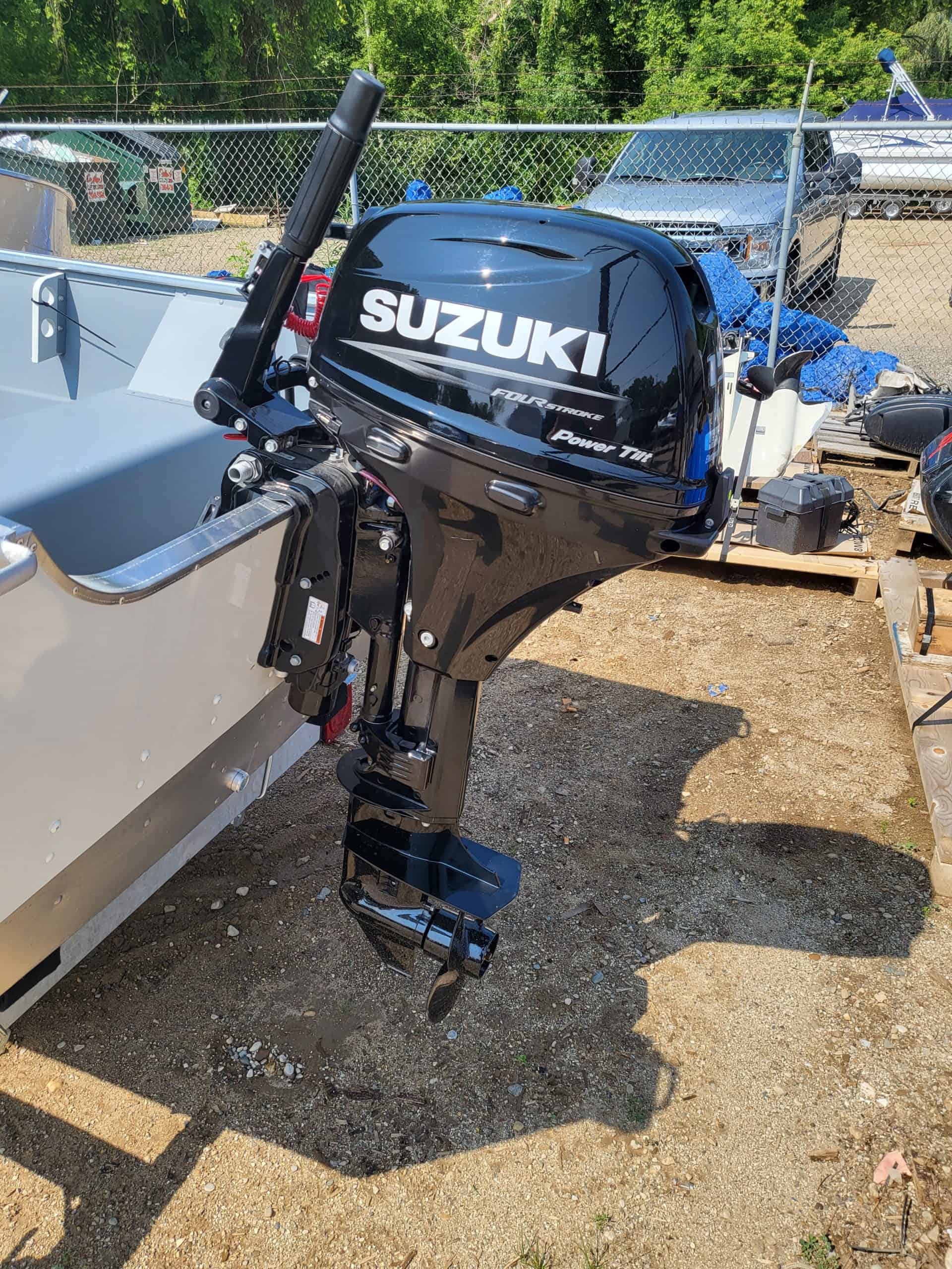 Black Suzuki outboard motor attached to boat for marine use.