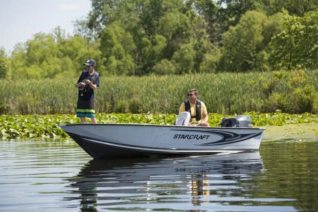 Two people fishing on a Starcraft Patriot 16 TL boat in a lake.