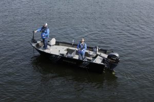 Two people inspecting a boat on the water with a remote-controlled drone.