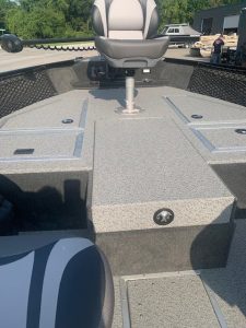 Bass boat deck with center seat and storage compartments for fishing gear.