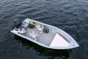 Fishing boat with seats and outboard motor on water.